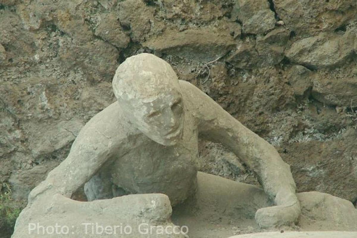 una statua di un ragazzo seduto su una roccia