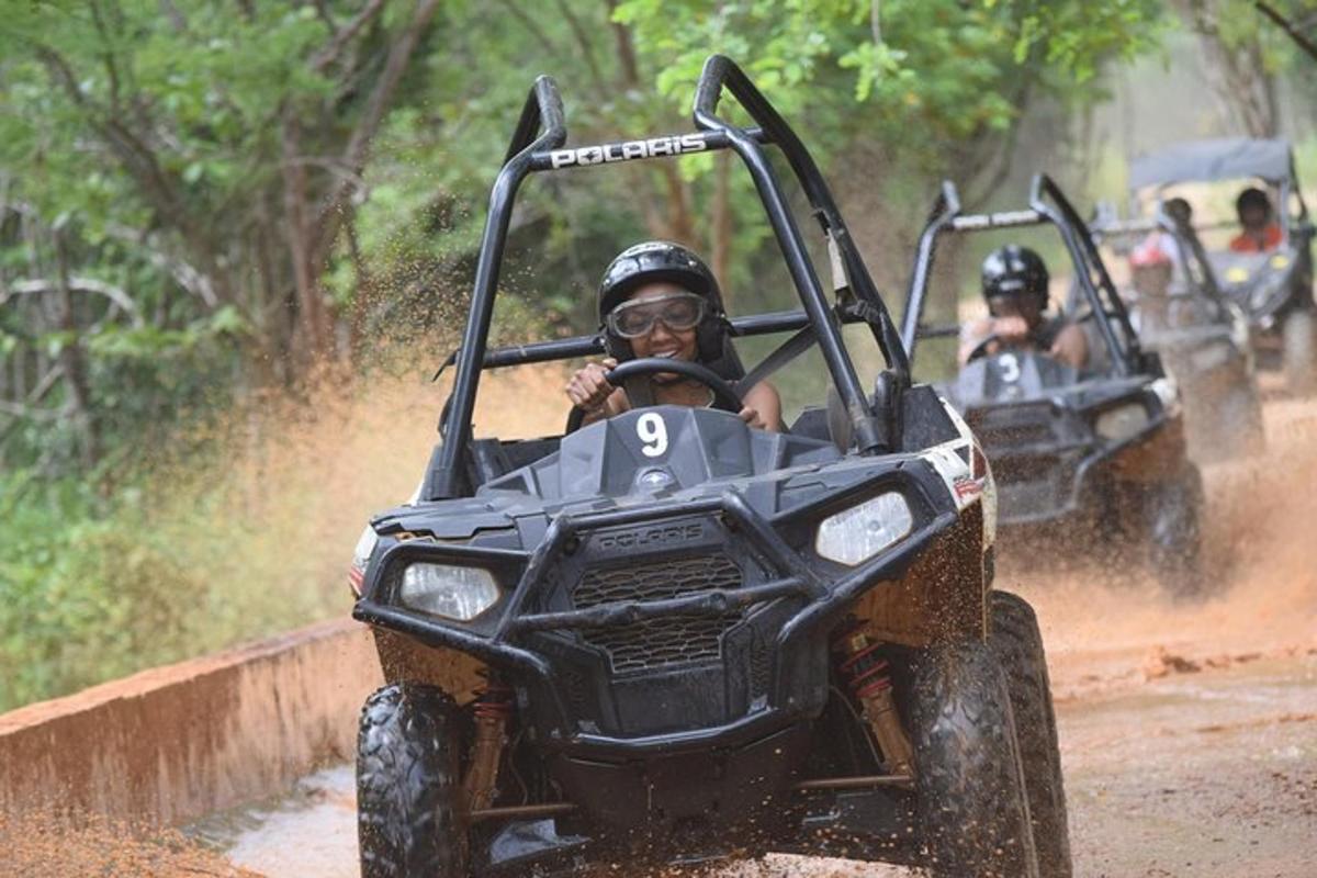 due persone che guidano un quad su una strada sterrata
