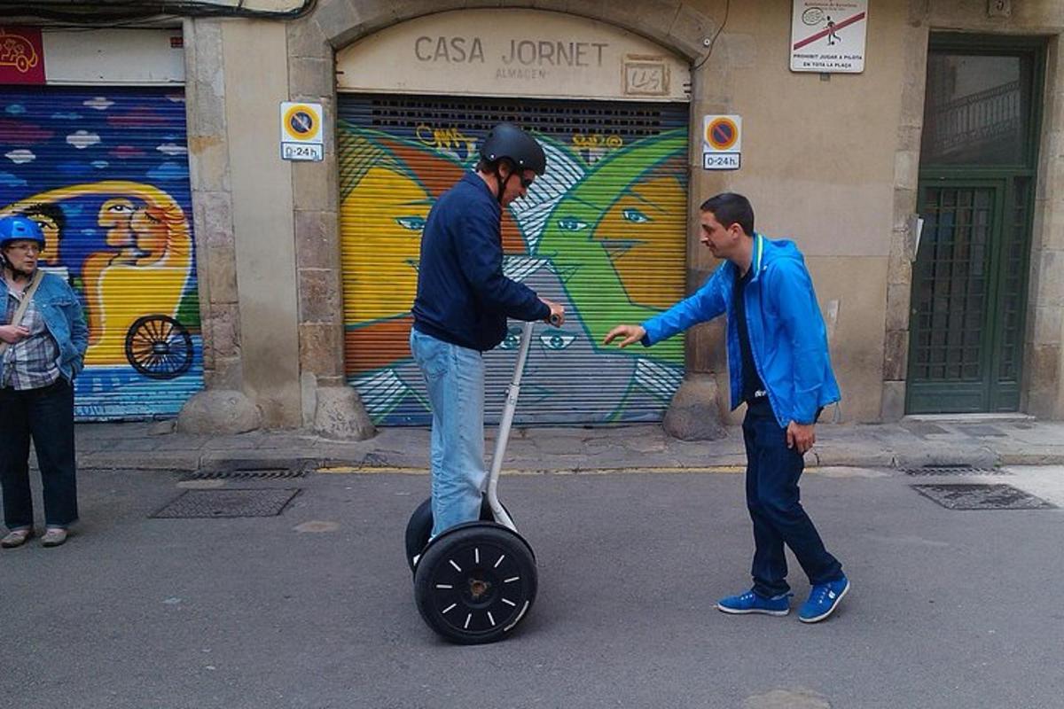 Dos hombres juegan con un scooter en la calle.