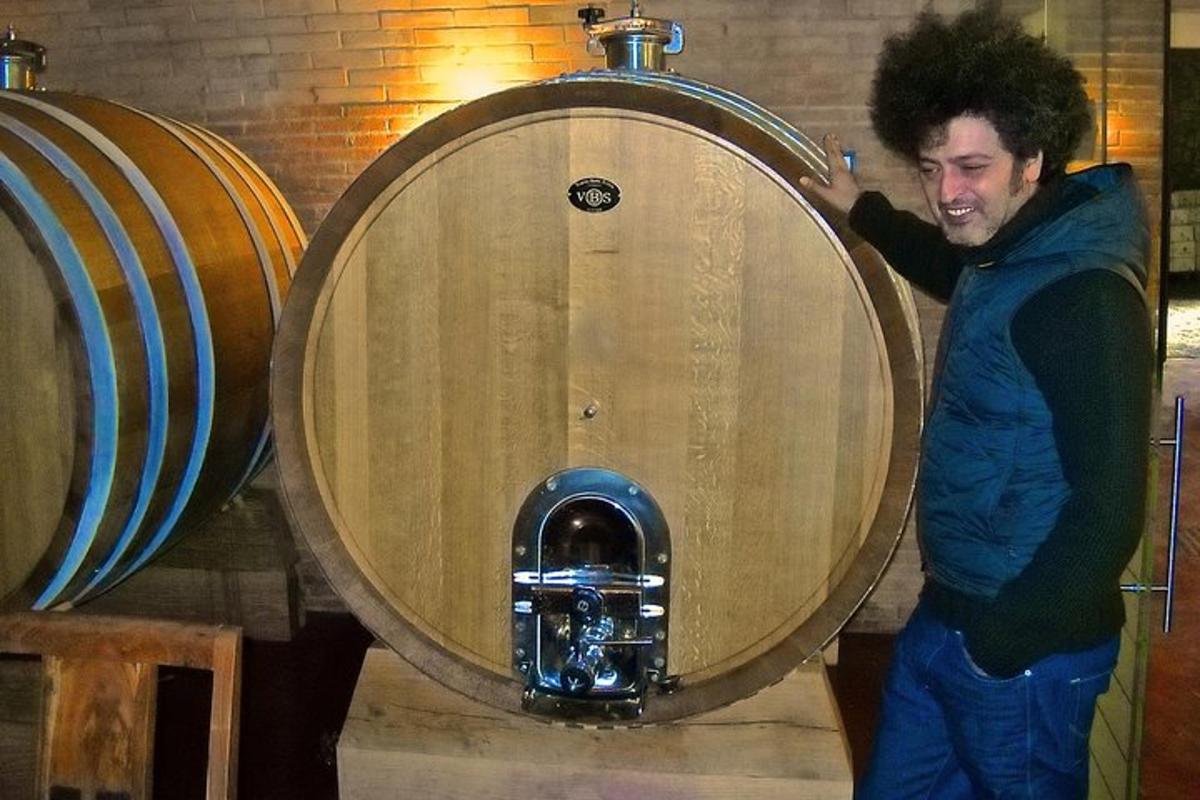 Un hombre está parado frente a un barril.