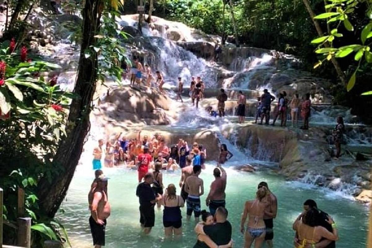 група хора във водата при водопад