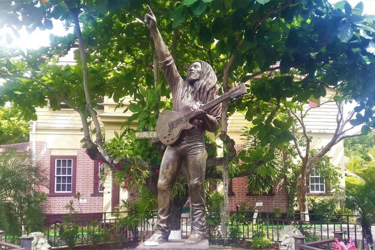 eine Statue eines Mannes mit einer Gitarre vor einem Gebäude
