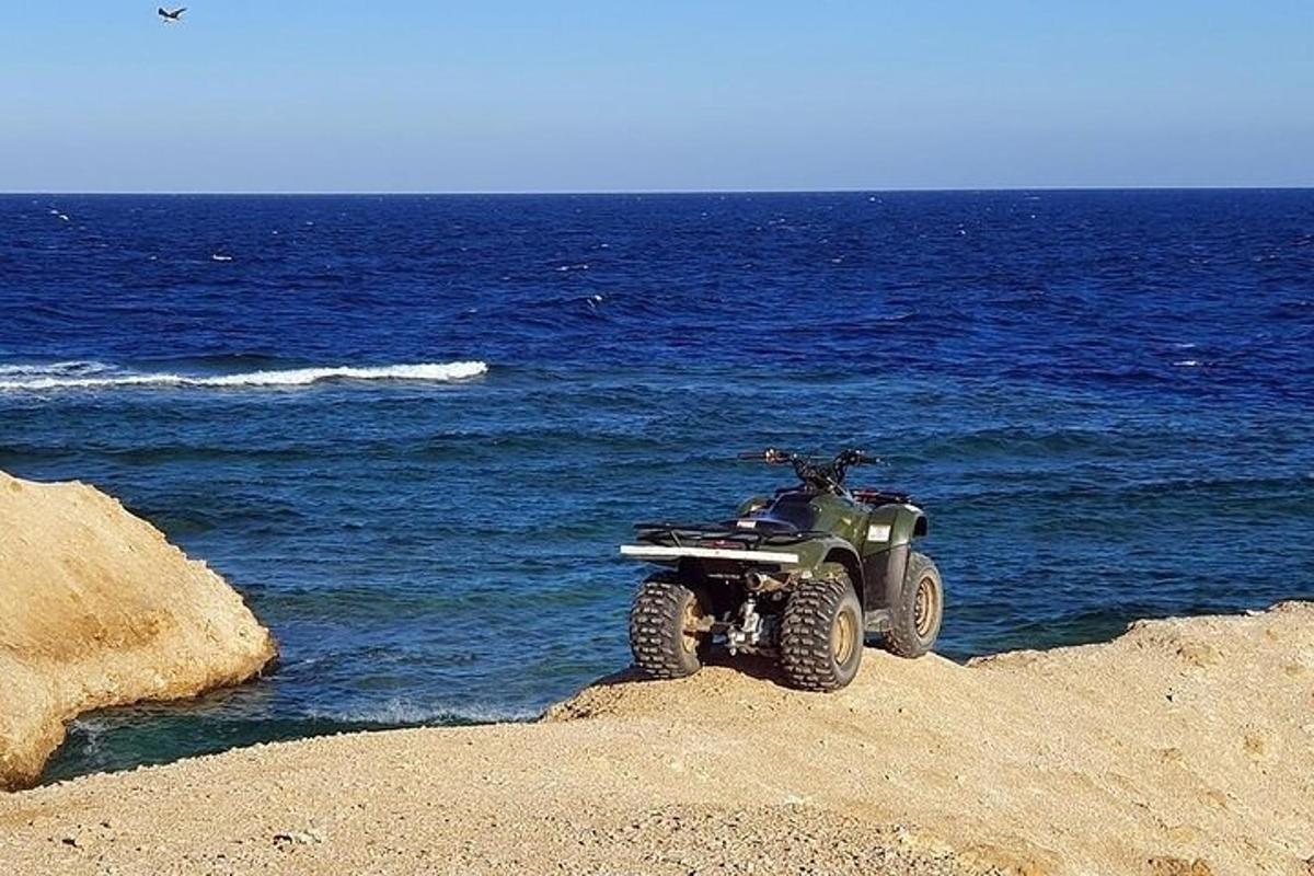 un quad parcheggiato su una spiaggia vicino all'oceano