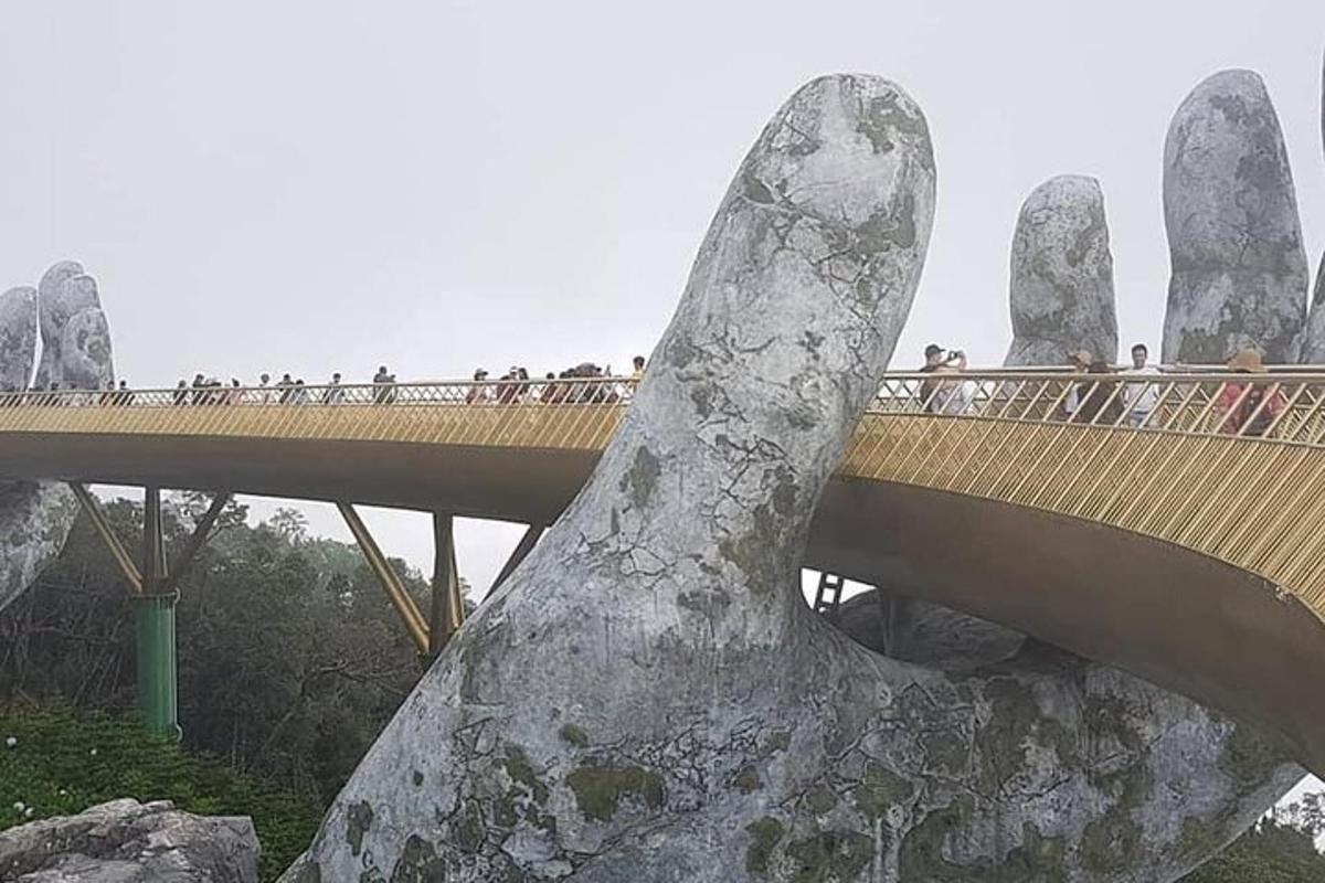 un ponte con una grande mano di pietra di fronte