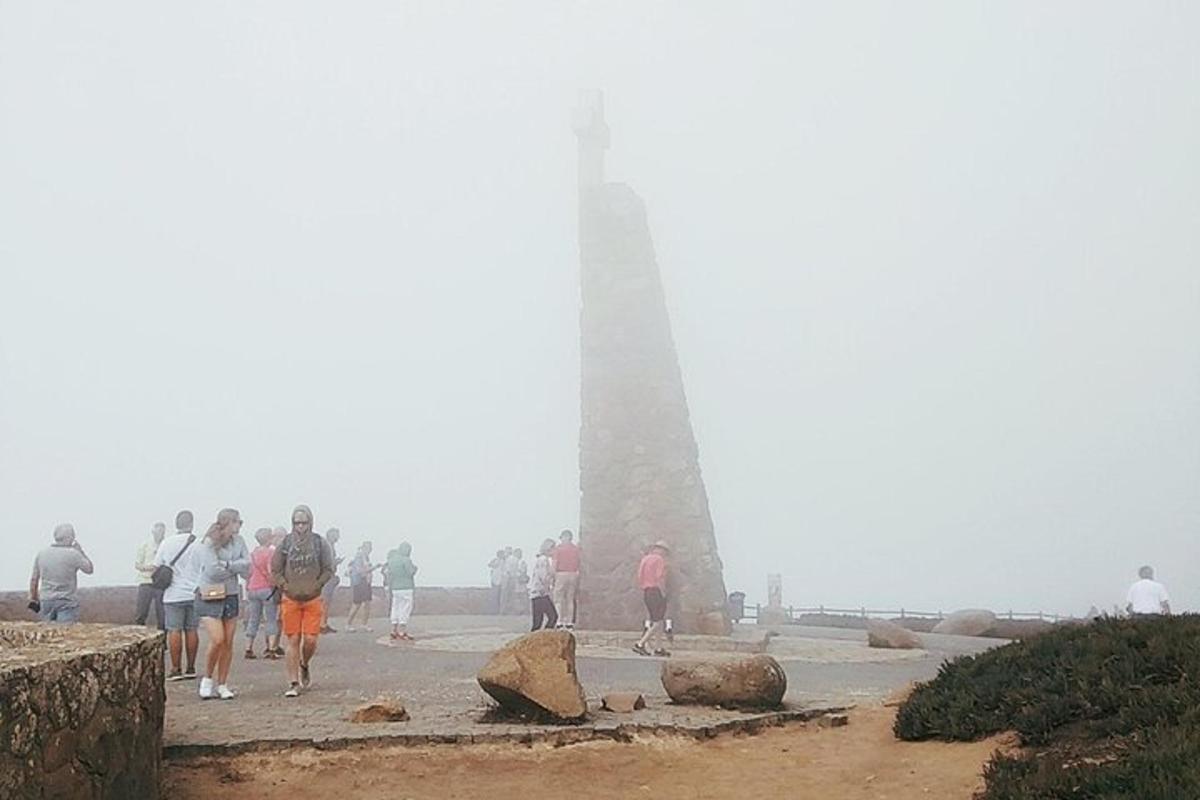 skupina ljudi, ki se sprehajajo po plaži s svetilnikom