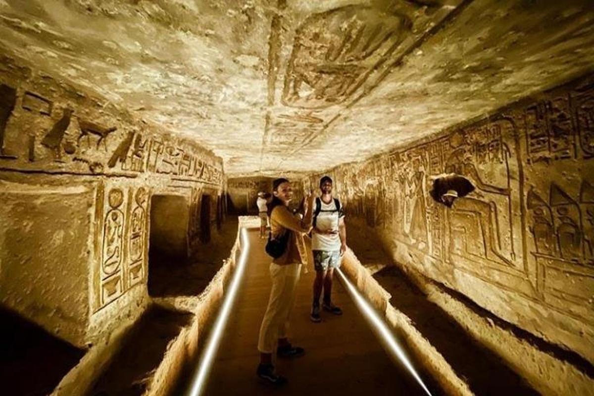 kaks inimest seisavad tunnelis, mille seintel on reljeefid