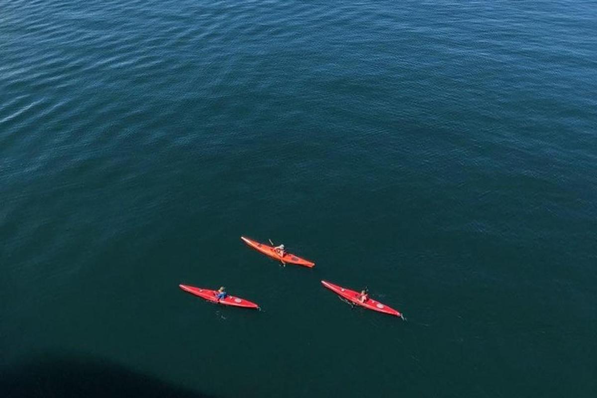 three red kayaks in the middle of the water