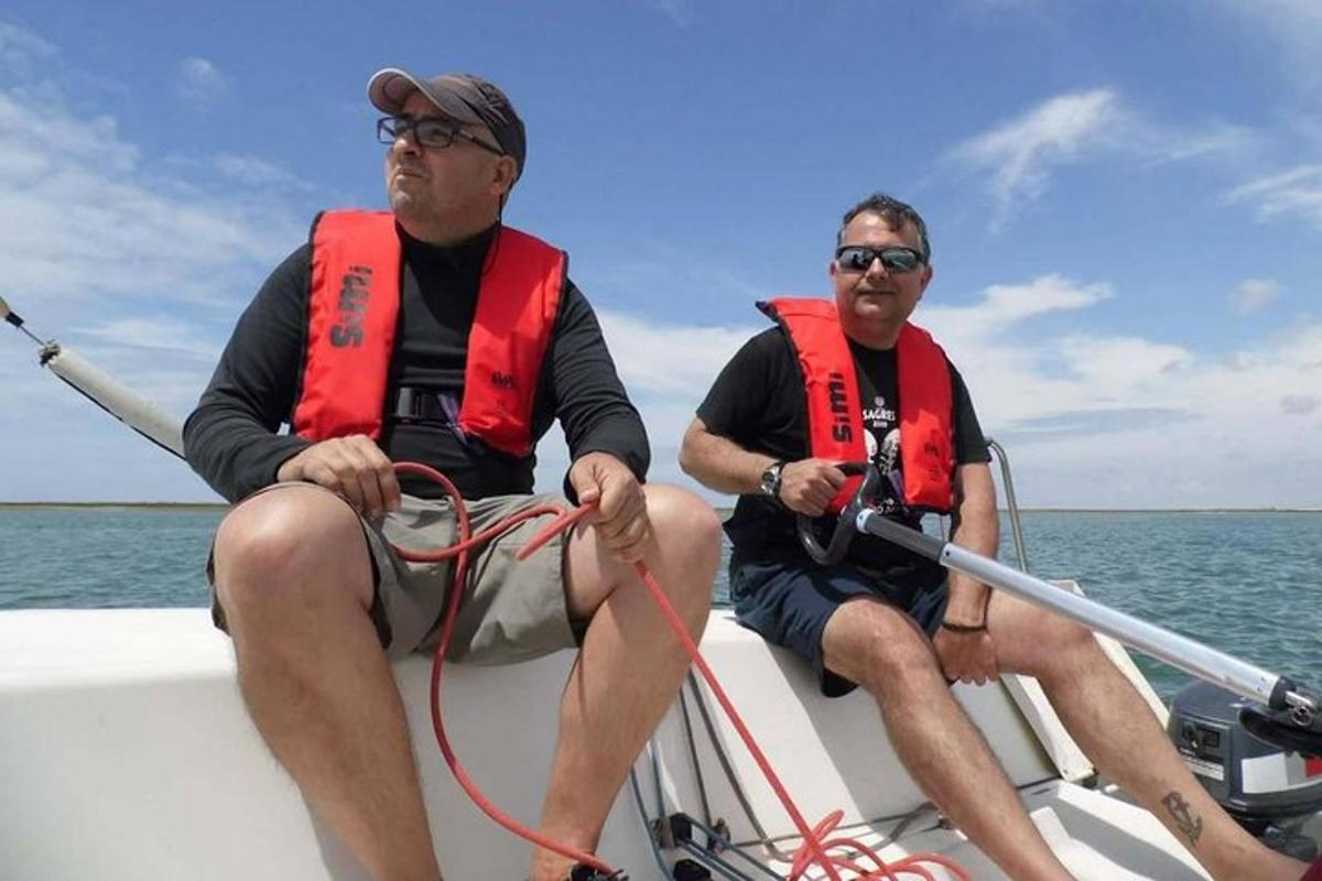 due uomini che indossano giubbotti di salvataggio seduti su una barca
