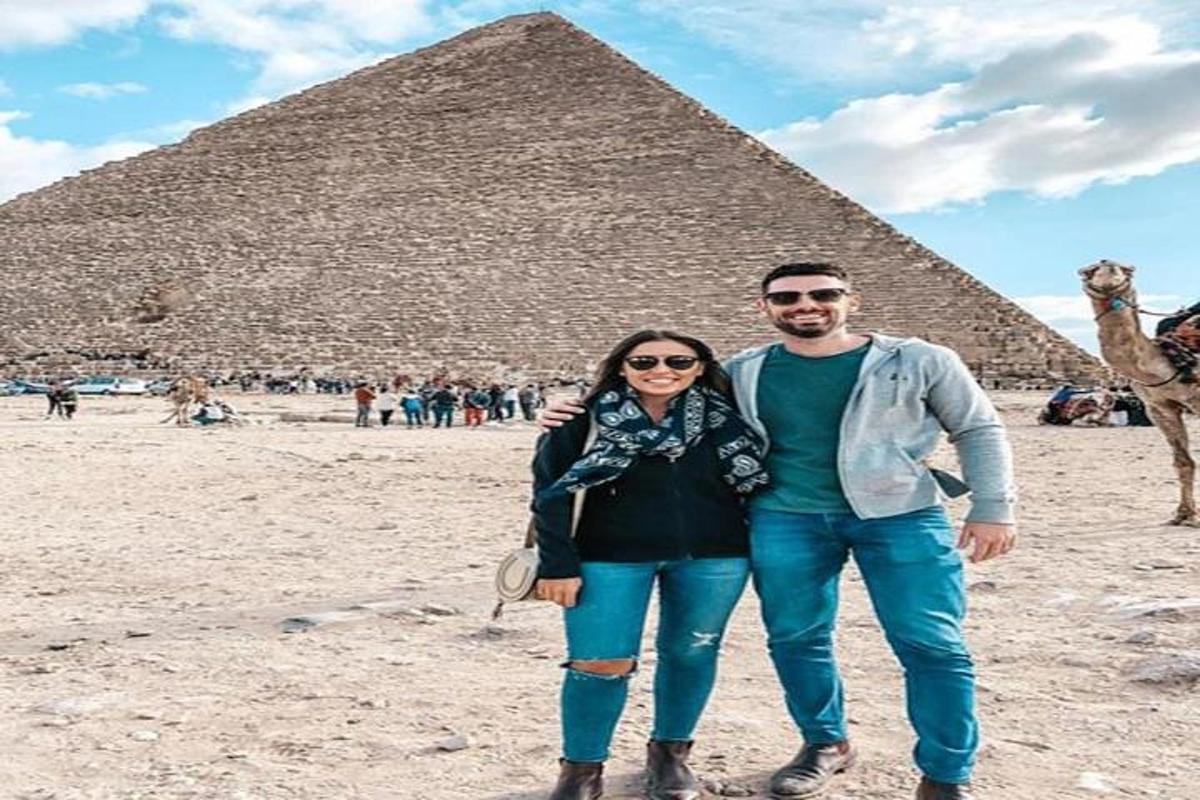 mies ja nainen seisovat pyramidin edessä