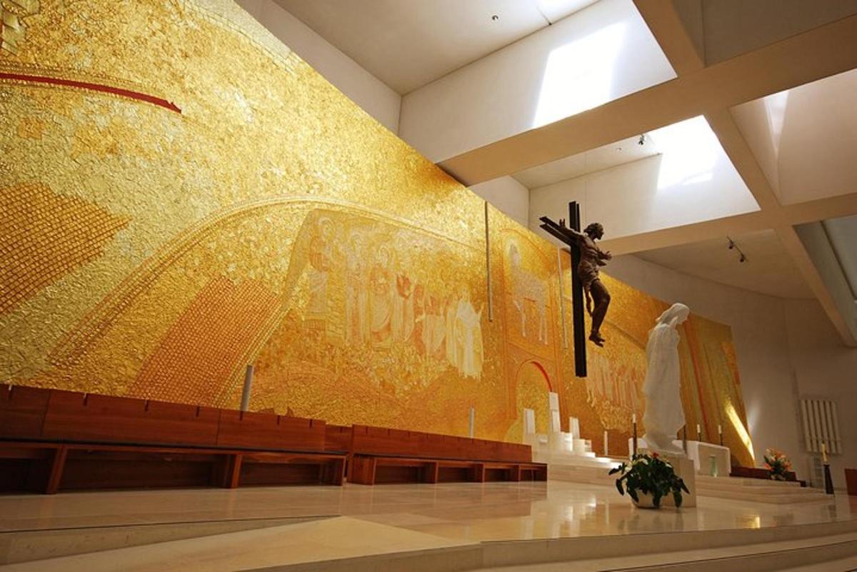un mur dans une église avec une statue d'un homme tenant une croix
