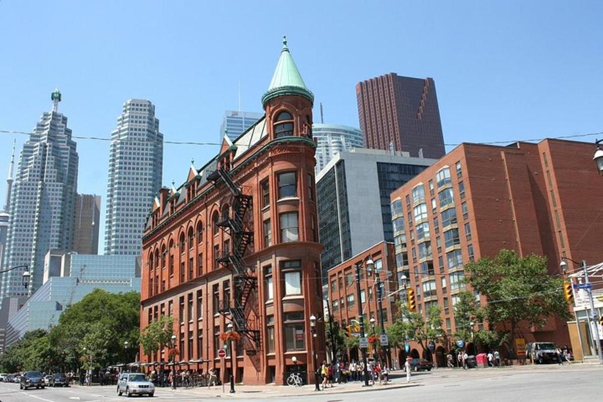 a tall red brick building with a green turret on a city street