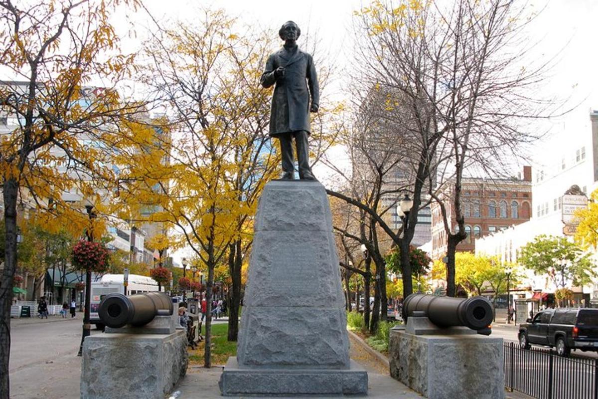 a statue of a man standing on top of a sidewalk
