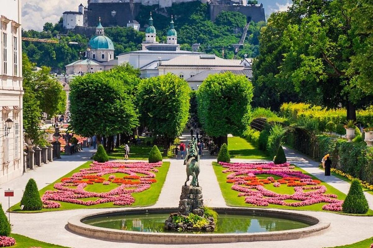 a garden with a fountain in the middle with flowers