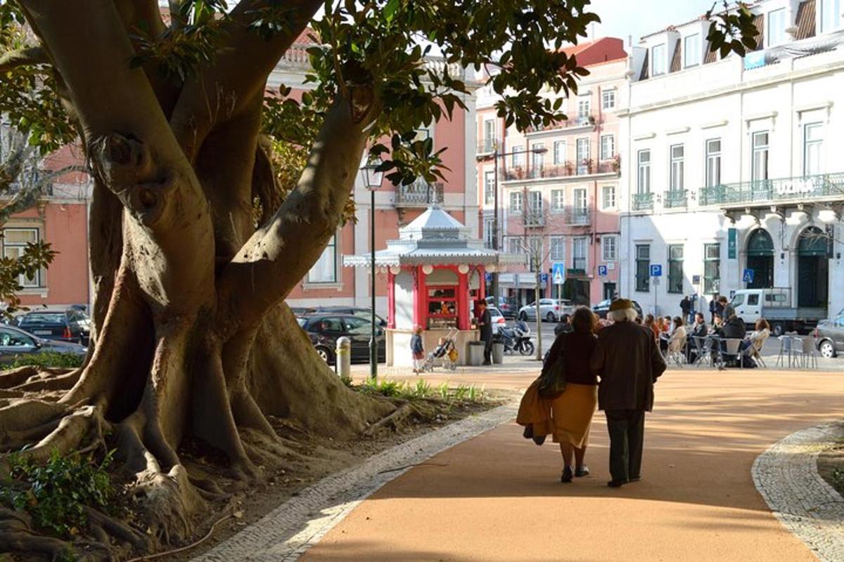 Δύο άνθρωποι περπατούν σε ένα πεζοδρόμιο δίπλα σε ένα δέντρο