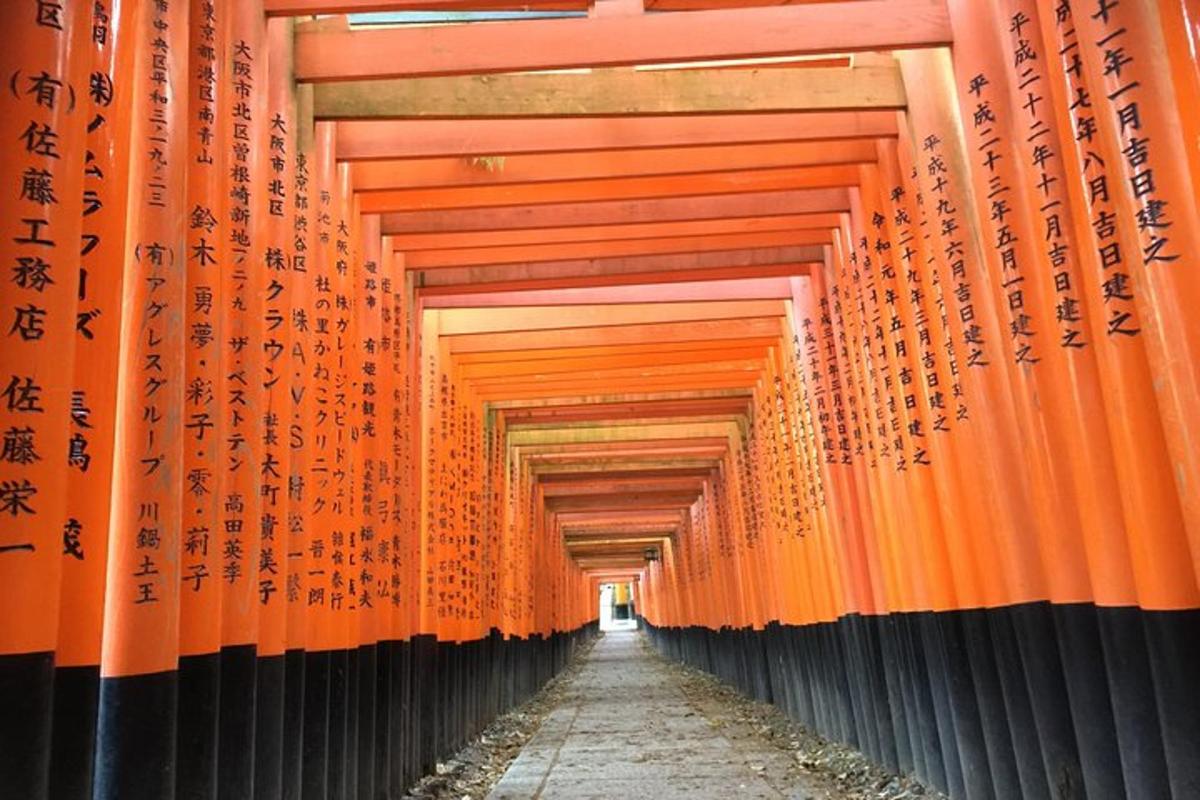 deretan gerbang torii berwarna oranye dengan tulisan di atasnya