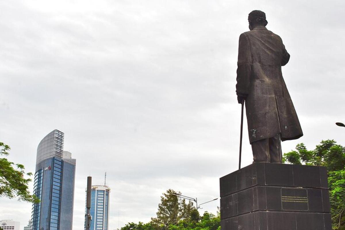 a statue of a man standing in front of a city