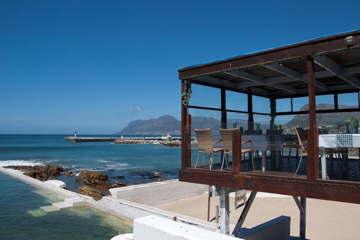 uma casa com uma mesa e cadeiras na praia