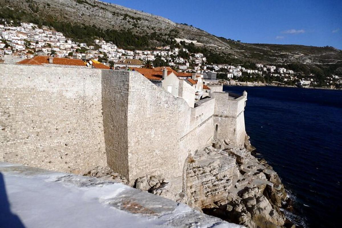 a wall next to a body of water with buildings