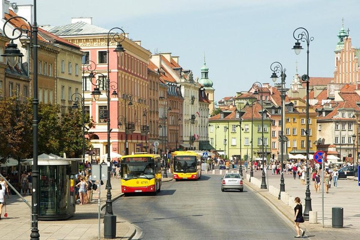 two buses driving down a city street with buildings