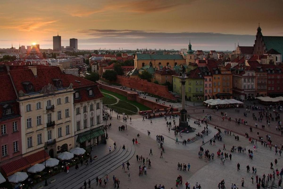 a group of people walking around a city at sunset