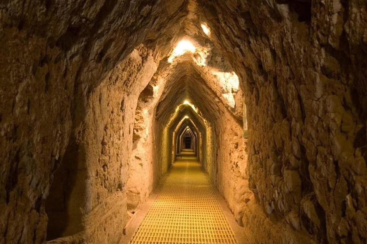 um túnel em uma caverna com uma luz no fim