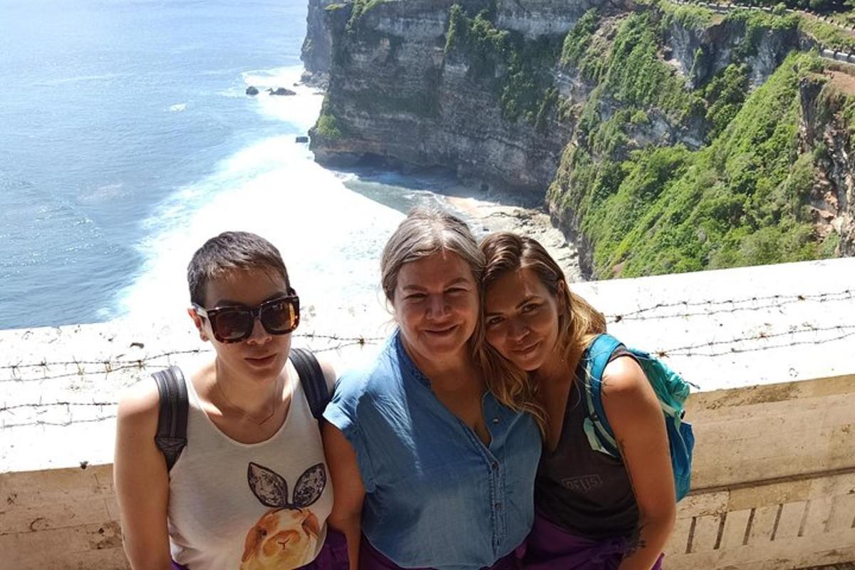 trei persoane care pozează pentru o fotografie pe coastă