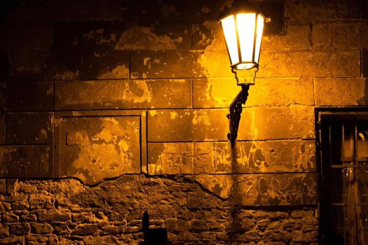 pouliční lampa na cihlové zdi v noci