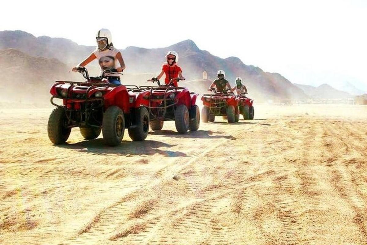 Un grupo de personas conduciendo vehículos todo terreno en el desierto.