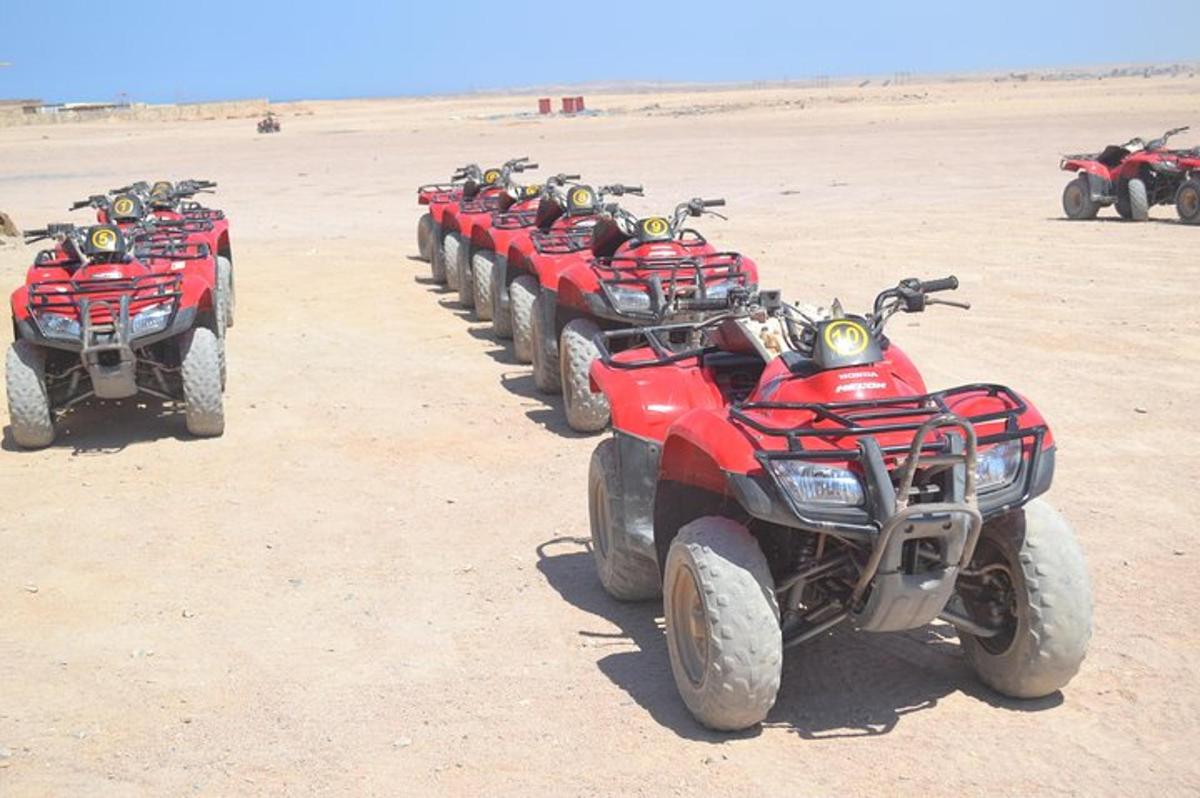 uma fileira de quadriciclos vermelhos estacionados no deserto