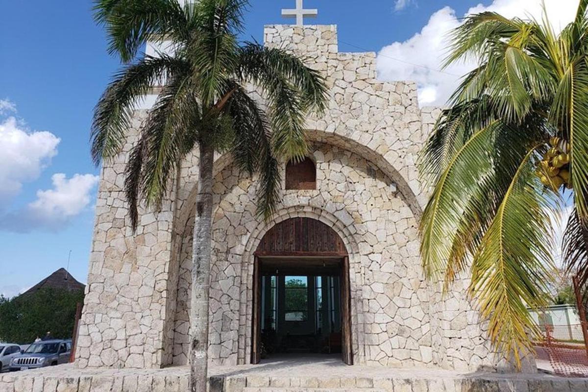 uma igreja com uma cruz e uma palmeira