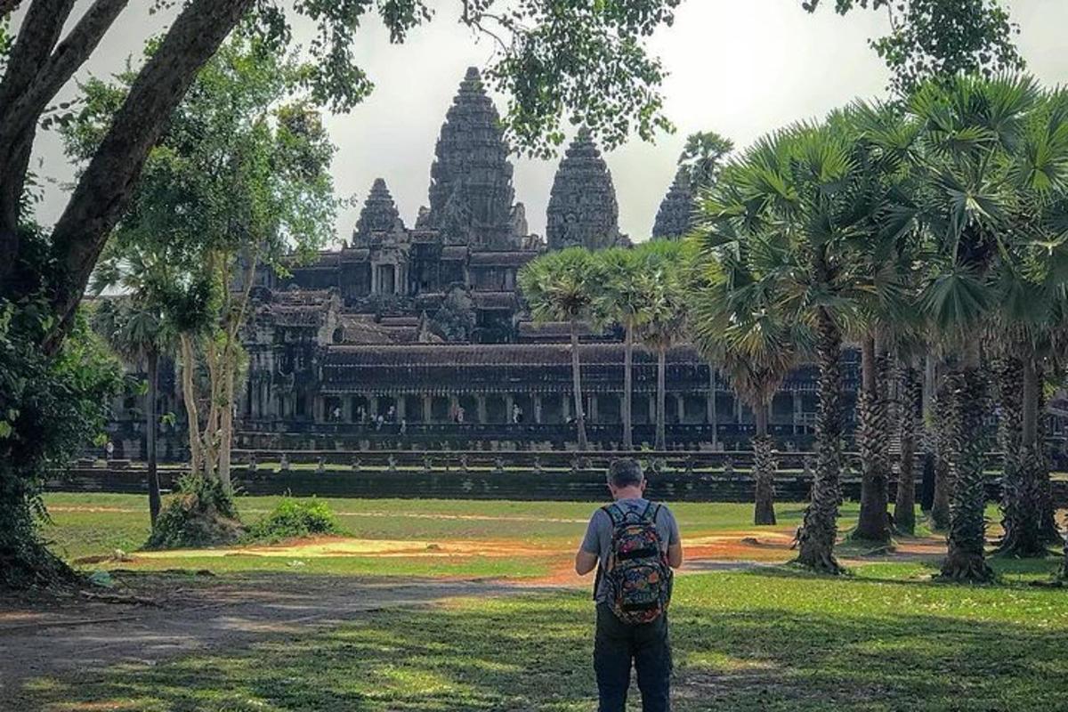 một người đàn ông đứng trong công viên trước một tòa nhà