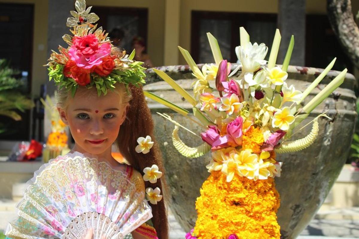 a doll with flowers on her head standing next to a vase