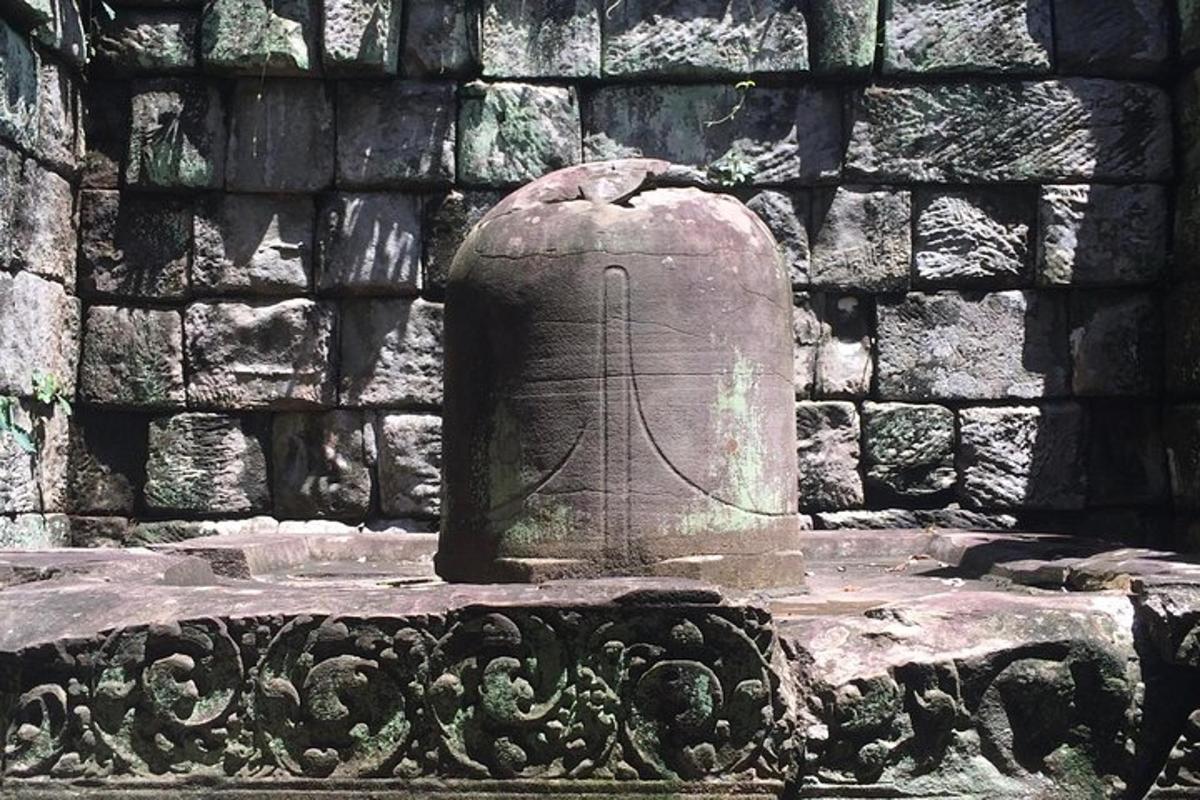 patung batu di hadapan dinding batu