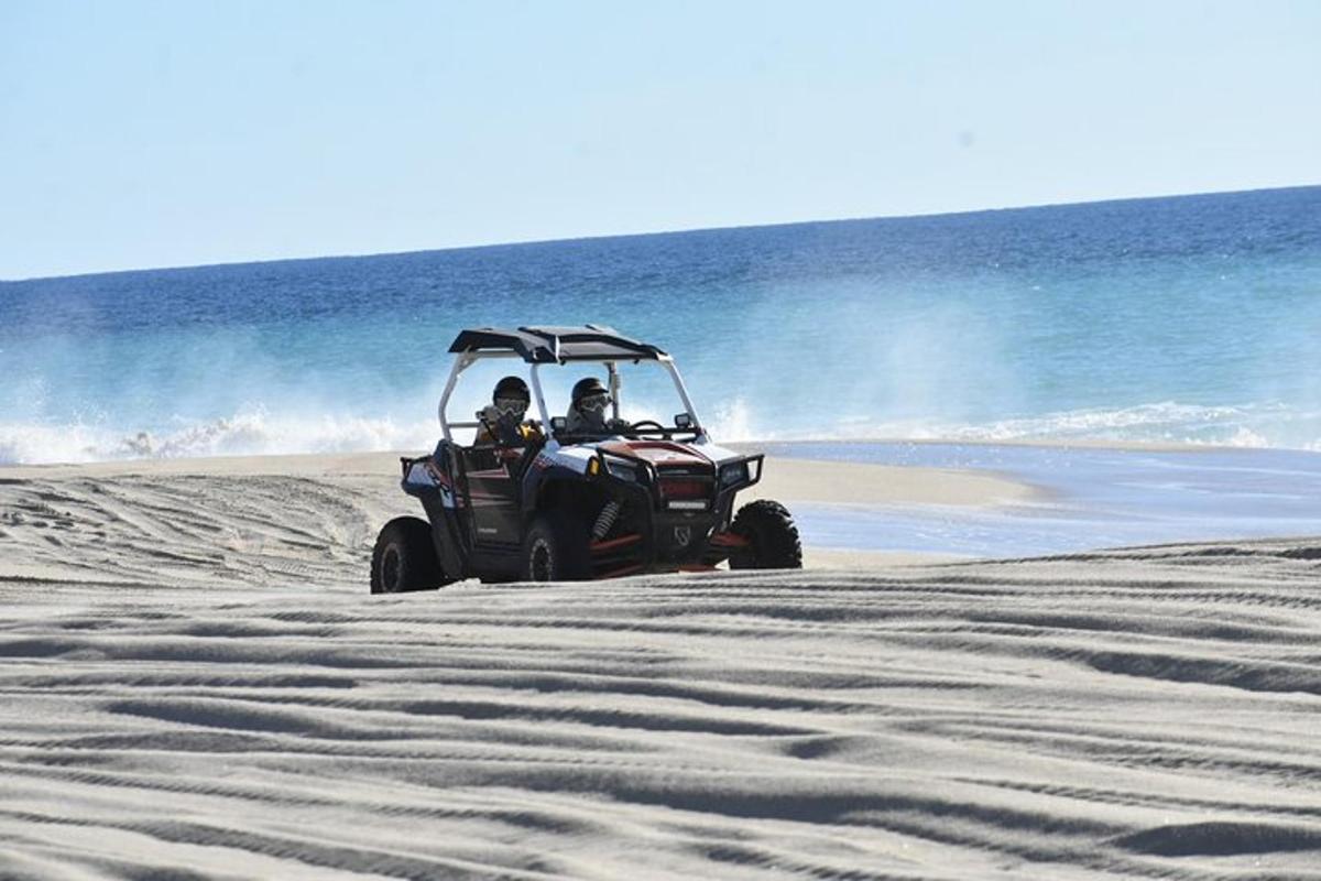 dve osebi, ki se vozita s štirikolesnikom na plaži