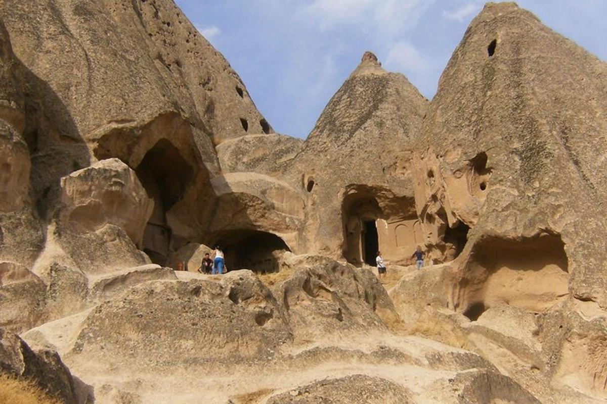 bir kaya oluşumunun üzerinde duran bir grup insan