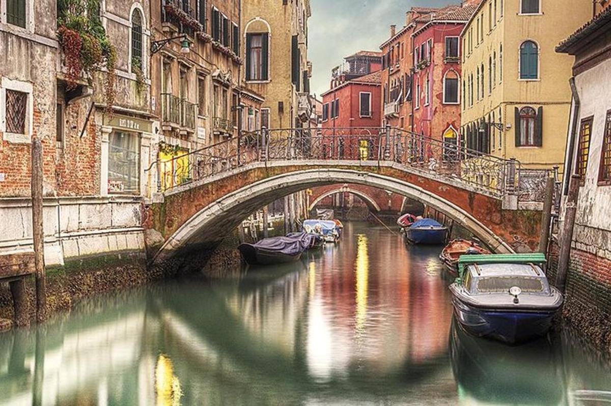 Un puente sobre un canal en una ciudad con barcos.