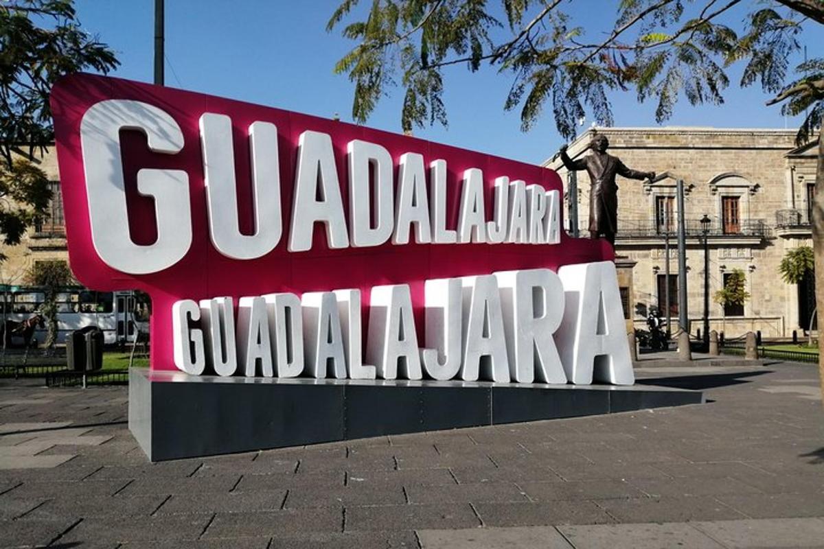 a sign for guadalajara in front of a statue