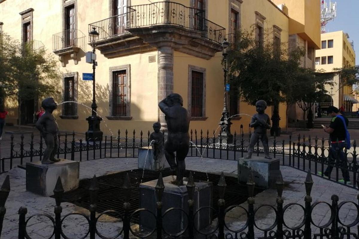 a statue in front of a fence in front of a building