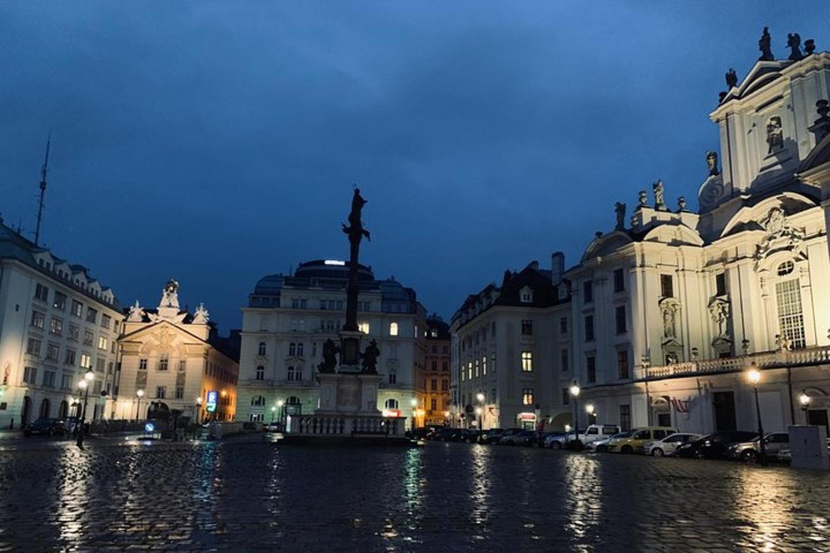 una ciutat de nit amb una estàtua davant dels edificis