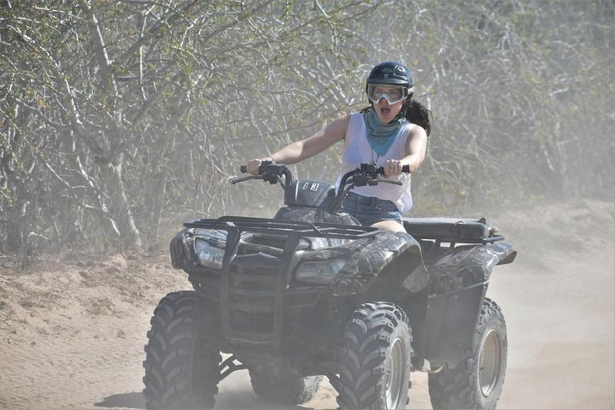 eine Frau, die auf einem Quad auf dem Feldweg fährt