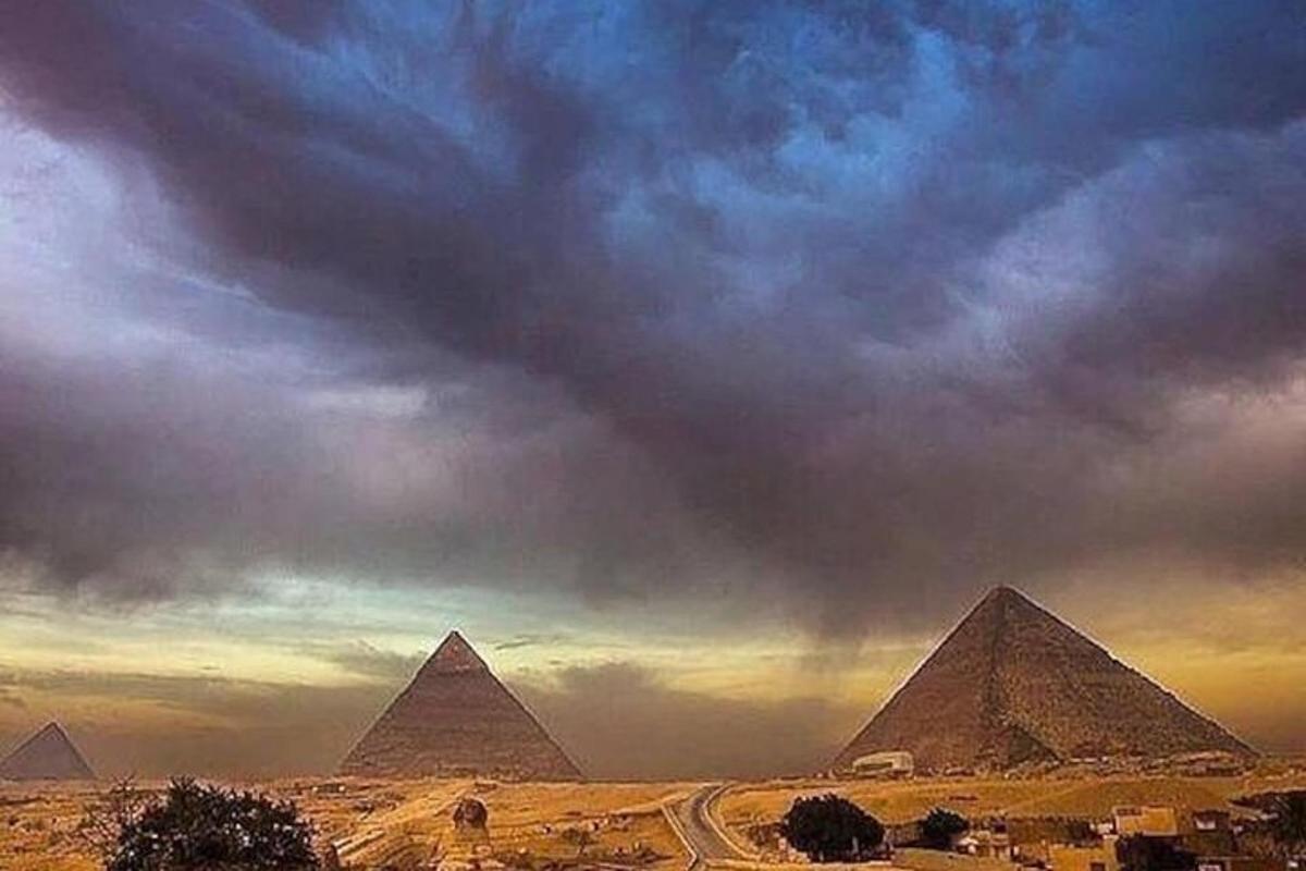 a view of the pyramids of giza under a cloudy sky