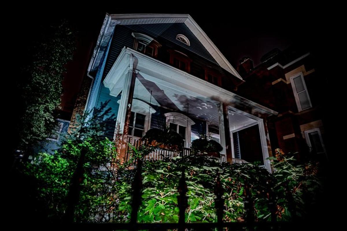 a house with a porch with white curtains on it