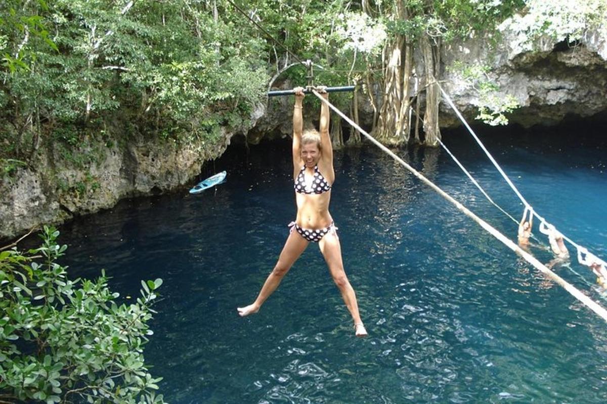 žena v bikinách skáče z lana do vody