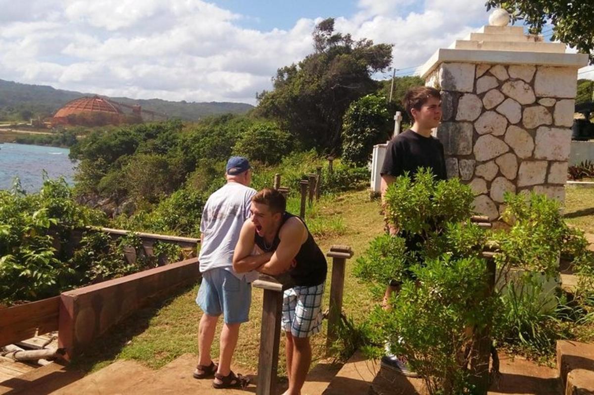 um grupo de homens em pé ao redor de um banco perto da água