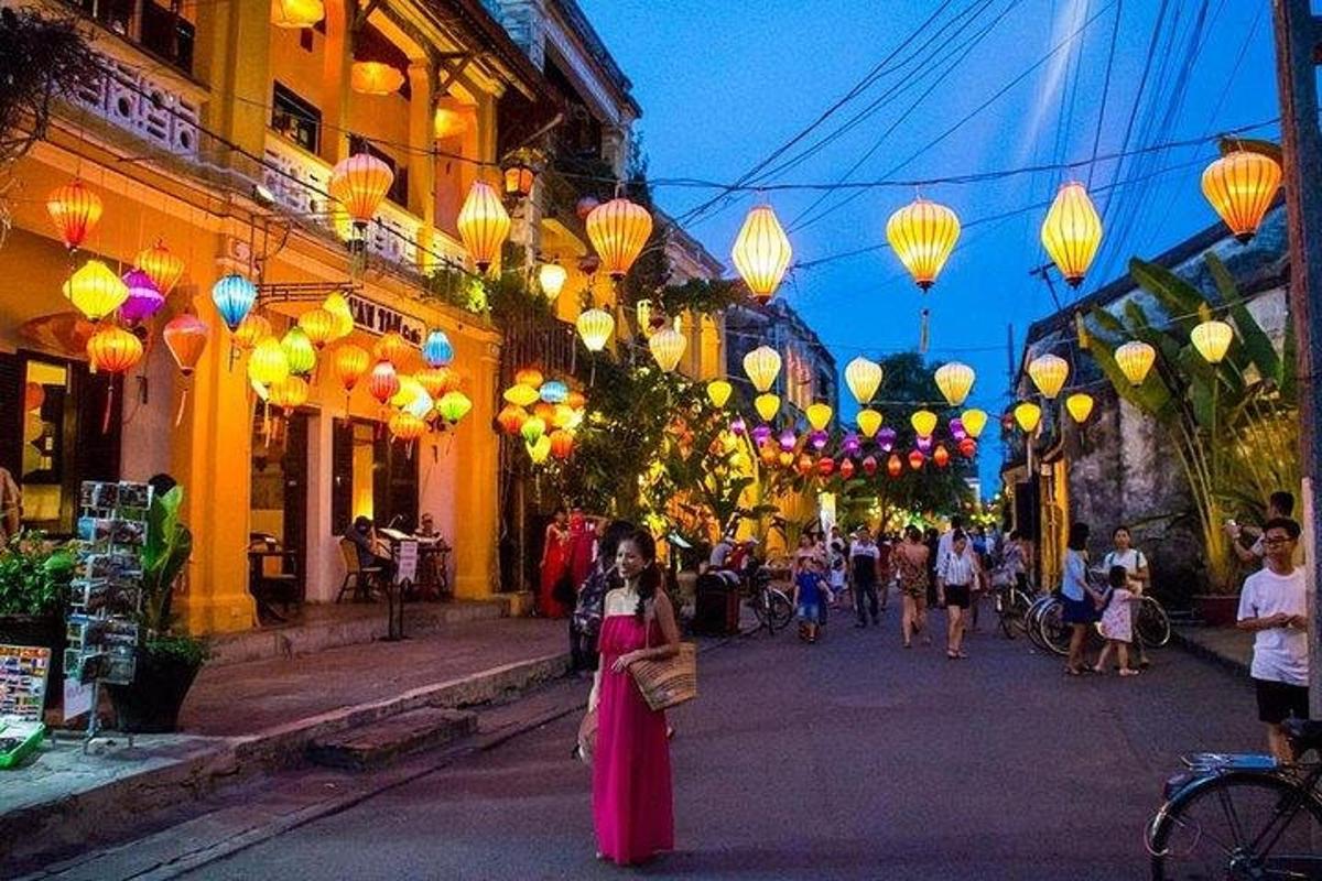 một người phụ nữ đang đi bộ trên phố với những chiếc đèn lồng