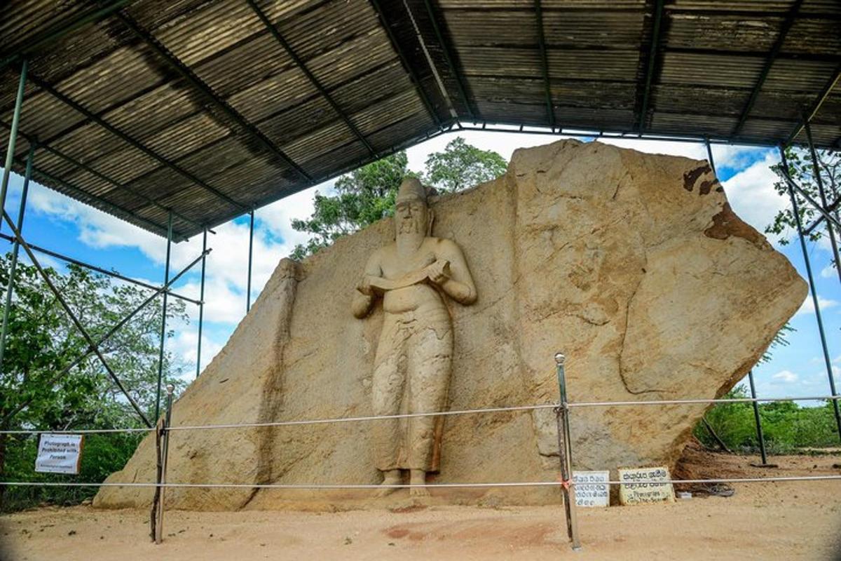 Una estatua de un hombre de pie junto a una gran roca.