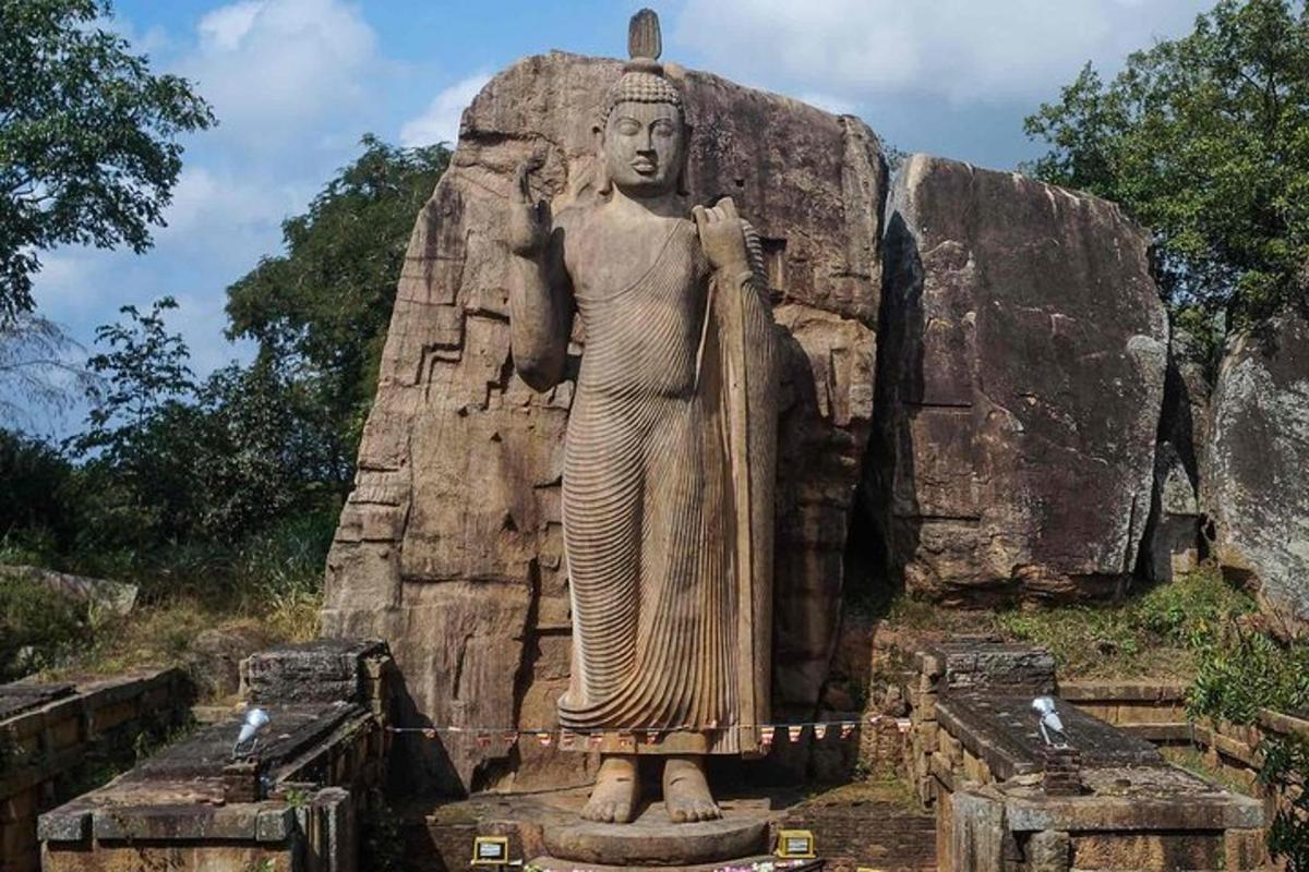 o statuie a unei femei care stă pe o stâncă