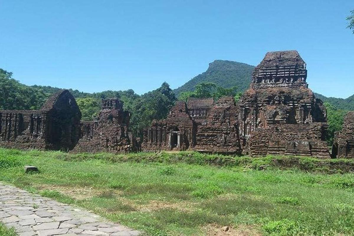 um edifício antigo em um campo com montanhas ao fundo