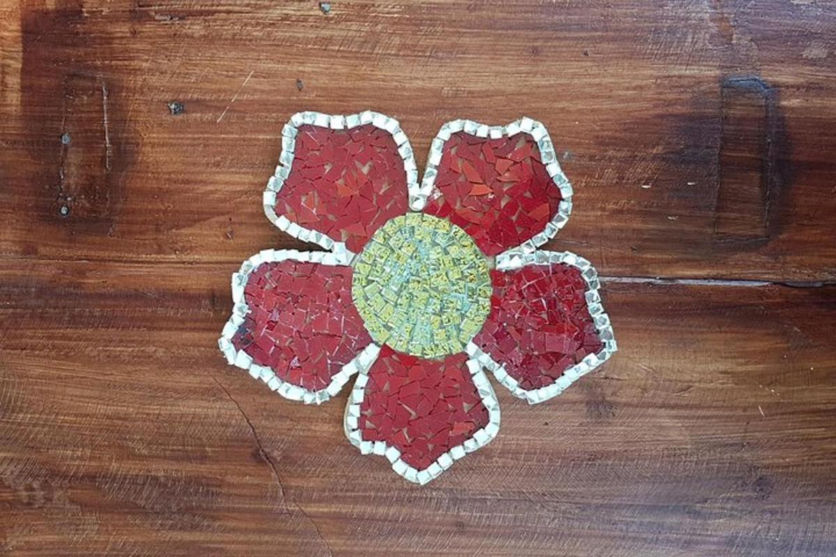 a red and white flower applique on a wooden table
