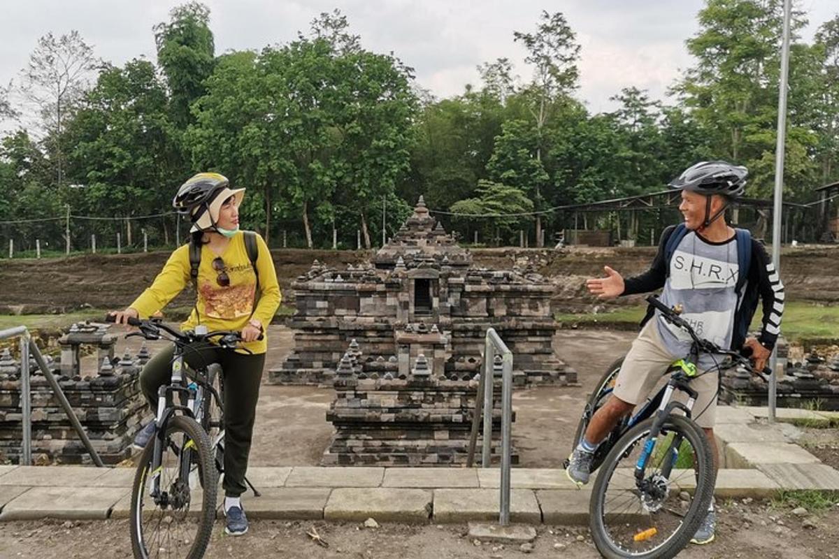 dvaja ľudia jazdiaci na bicykloch pred chrámom